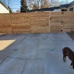 Privacy wood fence installed between two houses. There is a gate on to the right.